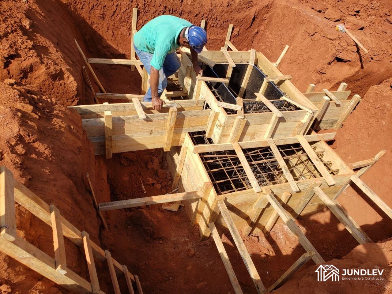 Fachada residencial em execução com volumetria contemporânea e preparação de acabamento pela JUNDLEV