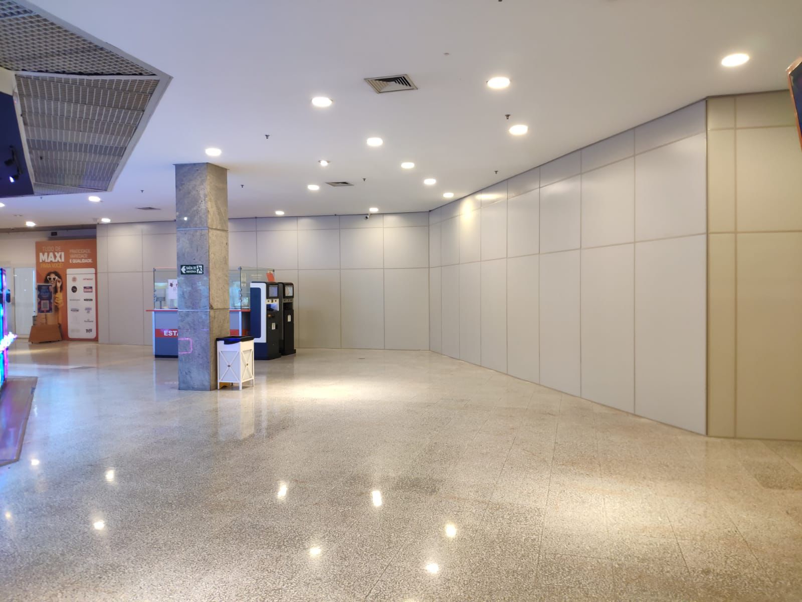 Fechamento interno em shopping com grande extensão linear, modulação regular e acabamento uniforme